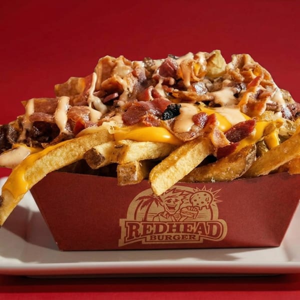 RedHead Burger loaded fries with melted cheese, bacon, and sauce in a branded container.